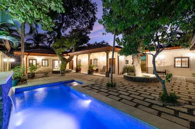 a swimming pool in front of a house at PuraVida lifestyle at Casa Caoba in Playa Flamingo