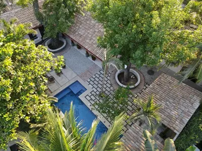 an overhead view of a swimming pool in a courtyard with trees at PuraVida lifestyle at Casa Caoba in Playa Flamingo