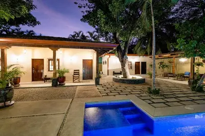 a house with a swimming pool in front of a house at PuraVida lifestyle at Casa Caoba in Playa Flamingo