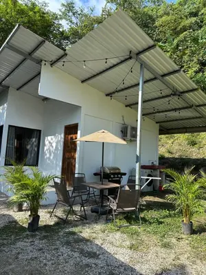 a patio with a table and chairs and an umbrella at El refugio in Nosara
