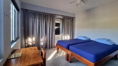 a bedroom with a blue bed and a table at Casa Celeste in Playa Pelada