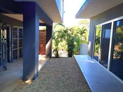 a hallway of a house with a courtyard with palm trees at Casa Celeste in Playa Pelada