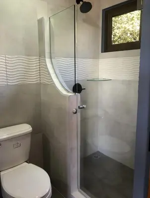 a shower with a glass door in a bathroom at Club Fred Aparthotel in Punta Mala