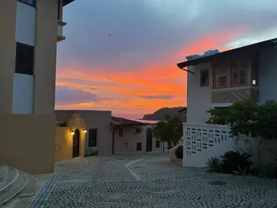 a sunset view of a house with the sky at LC Casa Olas in Playa Danta