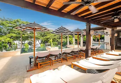 a patio with tables and chairs and umbrellas at LC Casa Olas in Playa Danta