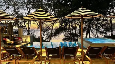 a group of chairs and umbrellas next to a swimming pool at LC Casa Olas in Playa Danta