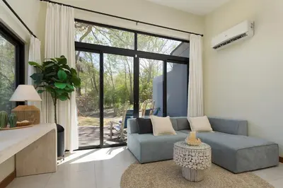 a living room with a blue couch and a large window at Luxury 3BR Gated Villa - Private Pool in Tamarindo in Tamarindo