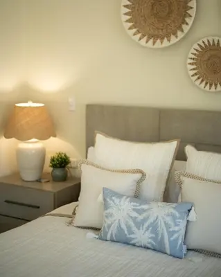 a bed with white and blue pillows and a lamp at Luxury 3BR Gated Villa - Private Pool in Tamarindo in Tamarindo