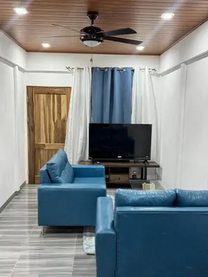 a living room with two blue couches and a tv at Harol reyes in Liberia