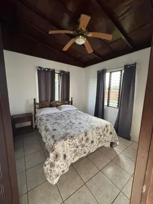 a bedroom with a bed and a ceiling fan at Casa Aurora, Nuevo Arenal in Arenal