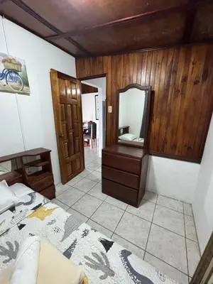 a bedroom with a bed and a dresser and a mirror at Casa Aurora, Nuevo Arenal in Arenal