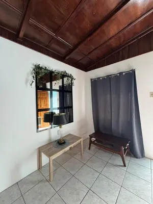 a living room with a table and a window at Casa Aurora, Nuevo Arenal in Arenal