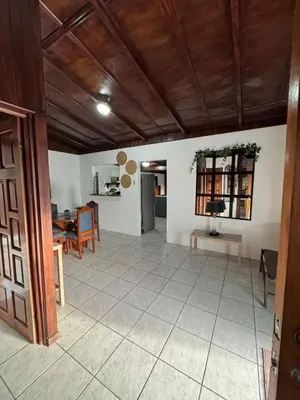 a living room with a table and a dining room at Casa Aurora, Nuevo Arenal in Arenal