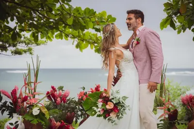 a bride and groom standing next to each other with flowers at Hotel Bohemian Lagarto in Santa Cruz