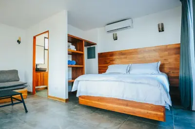 a bedroom with a large bed with a wooden headboard at Hotel Bohemian Lagarto in Santa Cruz