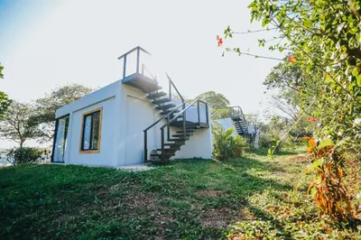 a small white house on a hill with a staircase at Hotel Bohemian Lagarto in Santa Cruz