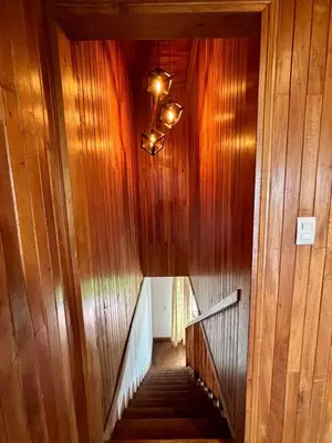 a staircase in a building with wooden walls and a chandelier at Casa 1440 in Monteverde Costa Rica