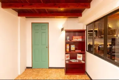 a room with a green door and a book shelf at Casa 1440 in Monteverde Costa Rica