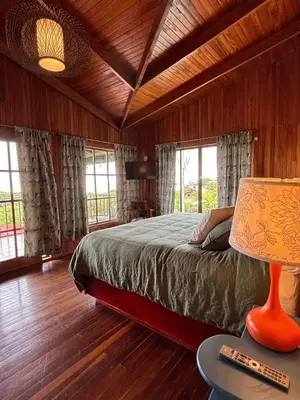 a bedroom with a bed and a table with a lamp at Casa 1440 in Monteverde Costa Rica