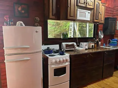a kitchen with a white refrigerator and a stove at Cabaña de Montaña El Jardin in Jardín