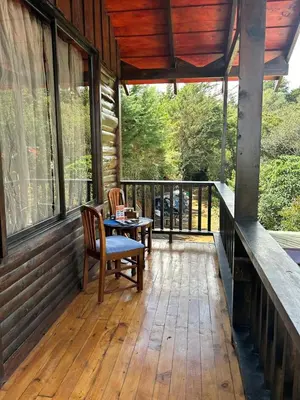 a screened in porch with a table and chairs on it at Cabaña de Montaña El Jardin in Jardín