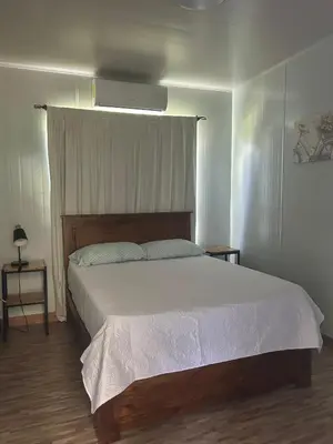 a bedroom with a large bed with white sheets at Casa Los Cedros in Río Cuarto