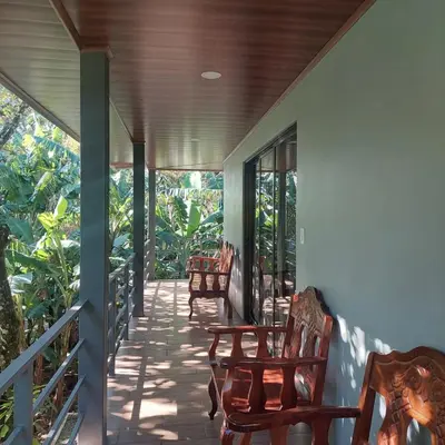 a porch with rocking chairs on a house at Family Cabin Surrounded by Nature - Patio & Pool in Sagrada Familia