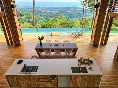 a kitchen with a counter and a view of a pool at The Zen, Award-Winning Sanctuary in Uvita in Uvita