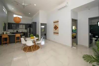 a kitchen and living room with a table and chairs at New! 3 Bedroom Villa in Uvita, Large Pool! in Uvita