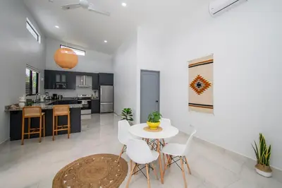 a kitchen and living room with a table and chairs at New! 3 Bedroom Villa in Uvita, Large Pool! in Uvita