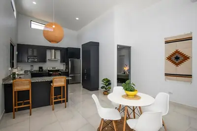 a kitchen and living room with a table and chairs at New! 3 Bedroom Villa in Uvita, Large Pool! in Uvita