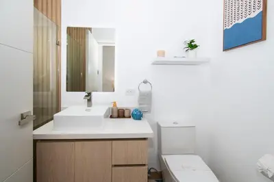 a bathroom with a sink and a toilet and a mirror at NEW! Villa, 3bdrs with AC, Pool, close to Marino Ballena in Uvita
