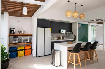 a kitchen with a white refrigerator and black cabinets at NEW! Villa, 3bdrs with AC, Pool, close to Marino Ballena in Uvita