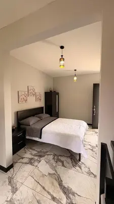a bedroom with a large bed and a marble floor at Apartamento Decrusi in Alajuela City