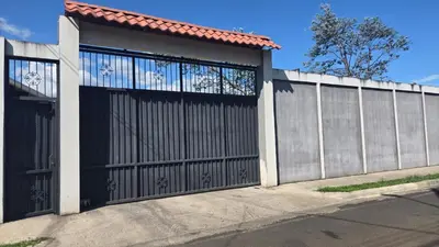 a house with a black gate and a fence at Apartamento Decrusi in Alajuela City