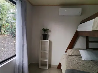 a bedroom with a bunk bed and a window at Casa Mi Bello Arenal, Rio el Salto and Fortuna in Fortuna