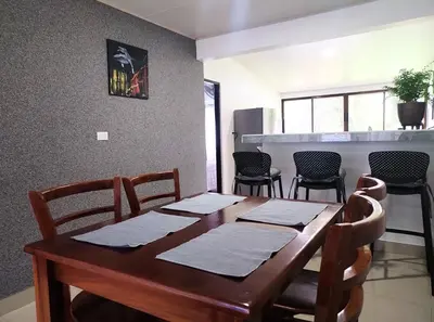 a dining room with a wooden table and chairs at Casa Mi Bello Arenal, Rio el Salto and Fortuna in Fortuna
