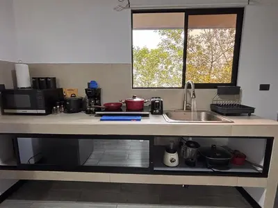 a kitchen counter with a sink and a window at Harmony Home La Fortuna in Fortuna