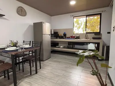 a kitchen with a dining table and a refrigerator at Harmony Home La Fortuna in Fortuna