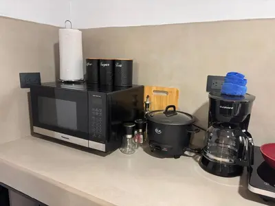 a kitchen counter with a coffee maker and a microwave at Harmony Home La Fortuna in Fortuna