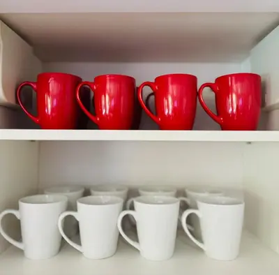 a row of red and white cups on a shelf at Elegant large house in Punta Leona Bamboo in Punta Leona