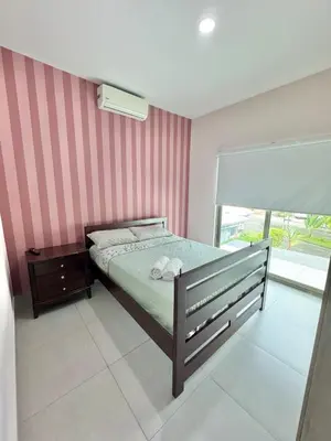 a bedroom with a bed with a striped wall at Elegant large house in Punta Leona Bamboo in Punta Leona