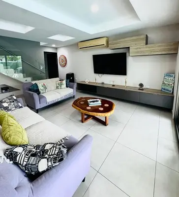 a living room with two couches and a flat screen tv at Elegant large house in Punta Leona Bamboo in Punta Leona