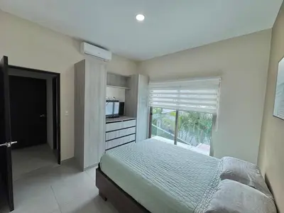 a bedroom with a bed and a television and a window at Elegant large house in Punta Leona Bamboo in Punta Leona