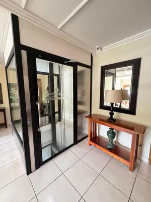 a room with glass doors and a table with a lamp at Hotel y Restaurante Costa del Sol in Mata de Limón