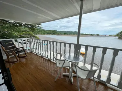 a balcony with a table and chairs next to the water at Hotel y Restaurante Costa del Sol in Mata de Limón