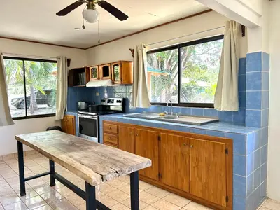 a kitchen with a wooden counter top and a table at Casa Fabis en Playa Junquillal, Playa a 600m in Santa Cruz