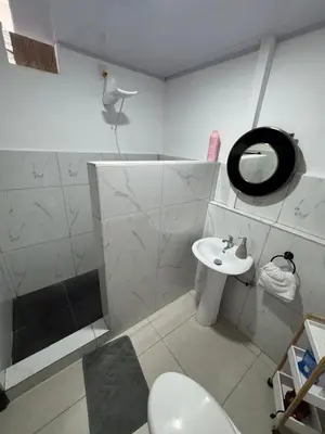 a white bathroom with a toilet and a sink at Floral Departments in Comunidad