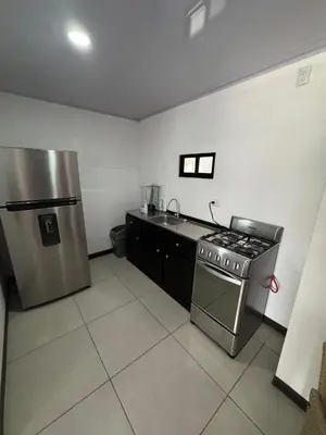 a kitchen with a stove and a stainless steel refrigerator at Floral Departments in Comunidad