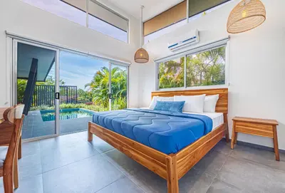 a bedroom with a bed and a large window at Villa Dos Vistas in Uvita